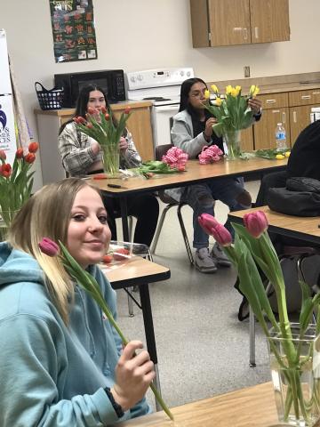 students adding tulips to vases