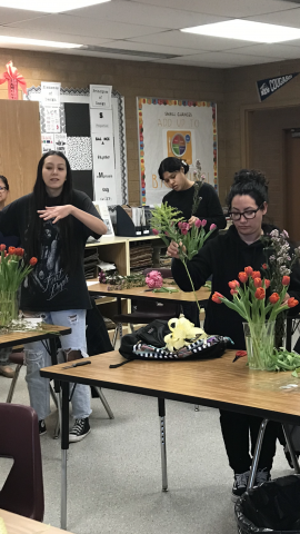 students adding filler flowers to vases