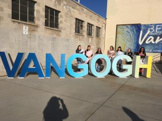 Students standing behind 3D letters spelling "VAN GOGH"