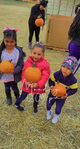 three children holding pumpkins