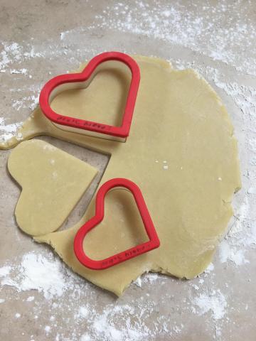 Heart-shaped cookie cutters on sugar cookie dough