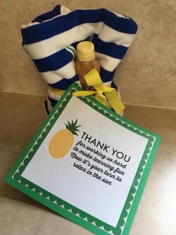 beach towel and sunscreen with tag saying "Thank you for working so hard to make learning fun, Now its your turn to relax in the sun."