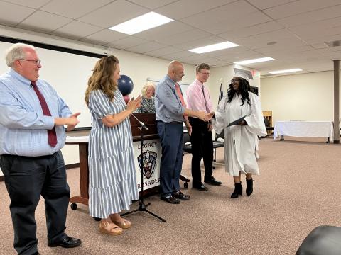 Nebo Board of Education shaking hand of Legacy graduate