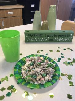 green plate with snack mix and St. Patrick's day themed decorations