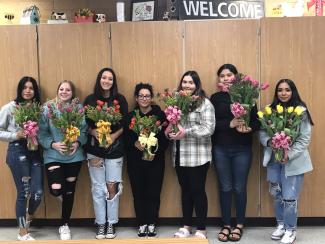 students holding tulip arrangements they made